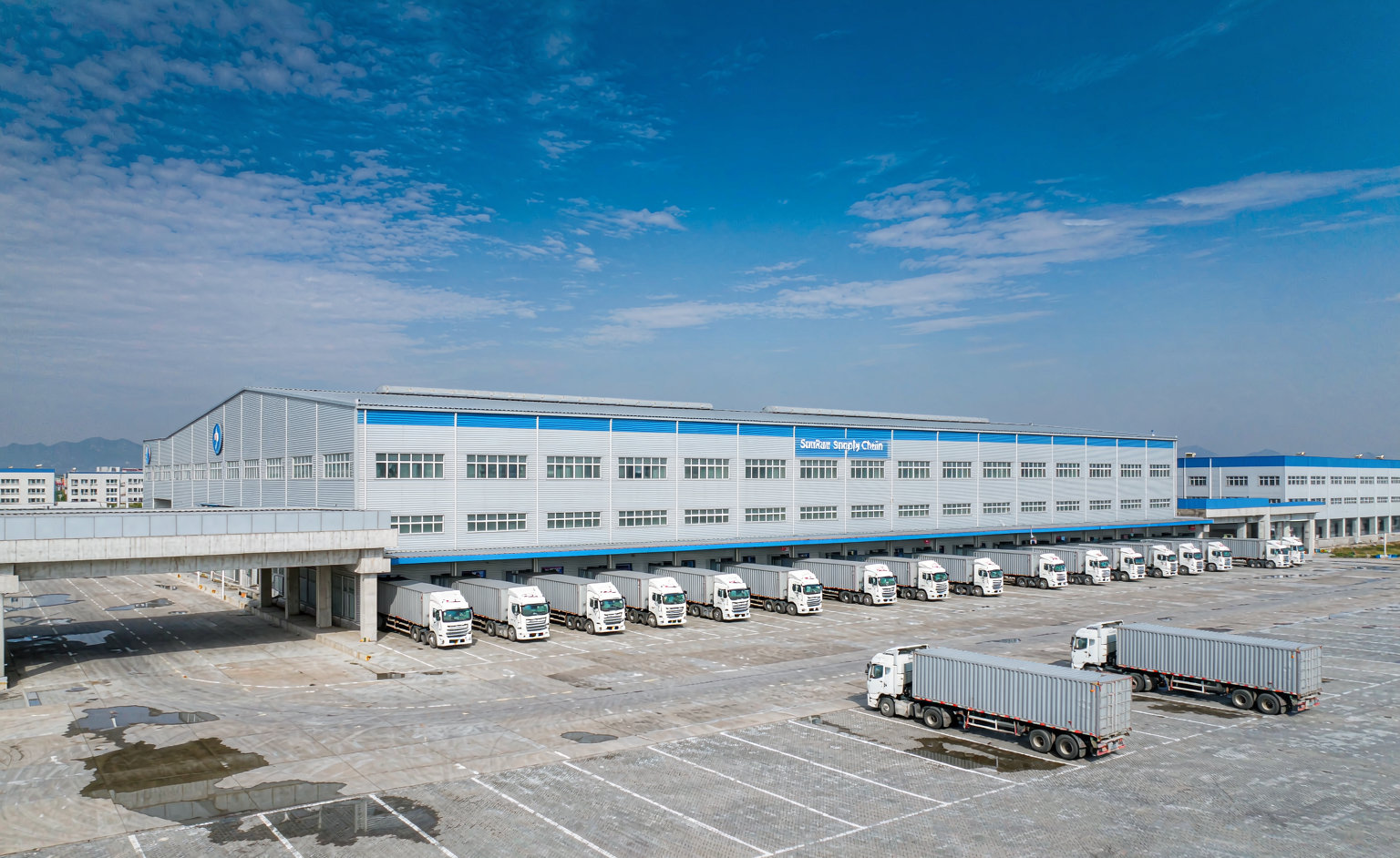 SunRun Supply Chain warehouse facility with branded signage and trucks queued for loading
